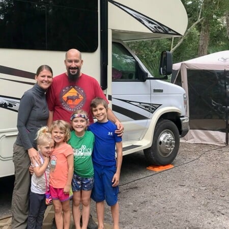 RVing family standing in front of their motorhome