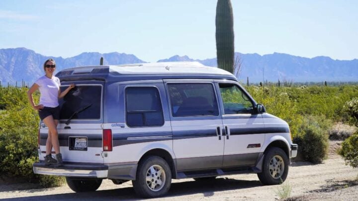 Chevy Astro van camper in the desert with woman on back bumper
