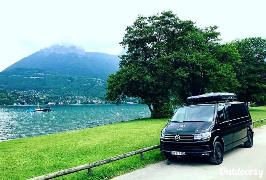 Volkswagen camper van rental in Europe parked near a beautiful lake