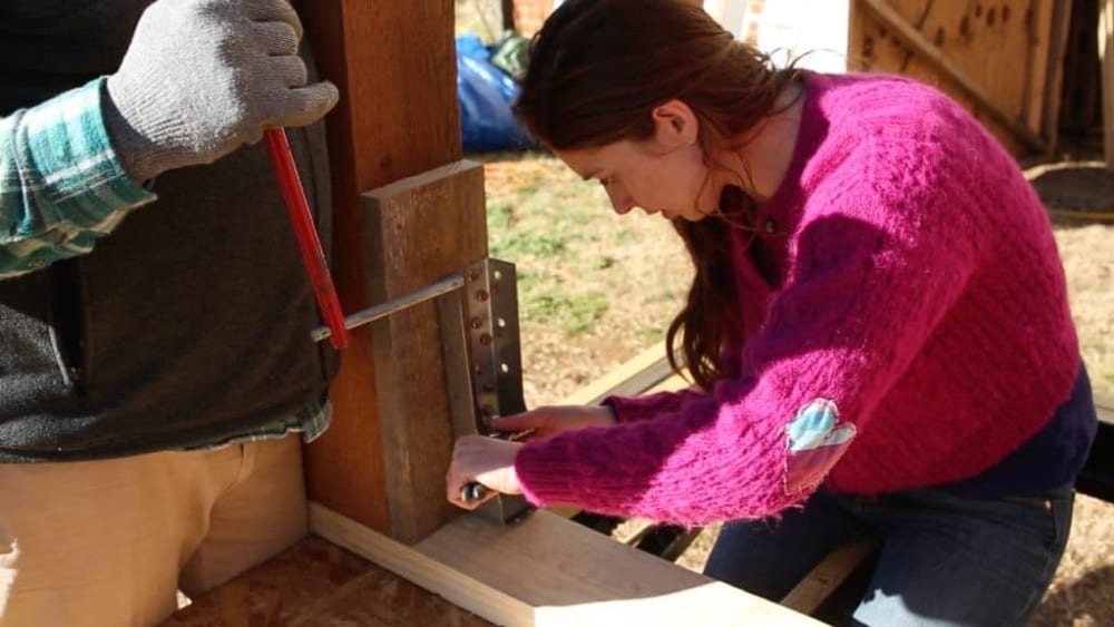 A couple works on building their dream tiny house trailer.