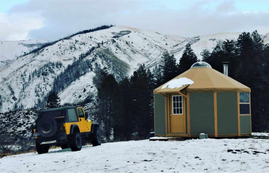 Green yurt off grid tiny home parked in the snowy mountains