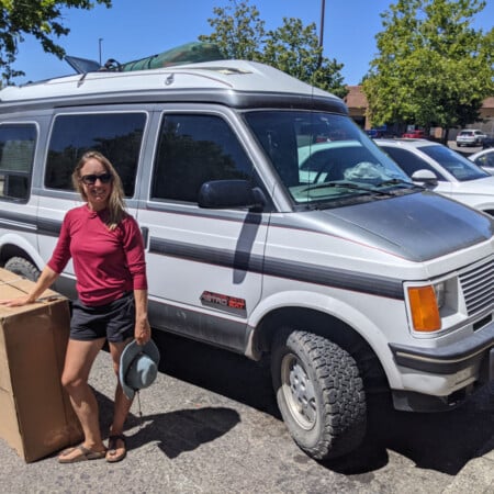woman standing next to a package received on the road