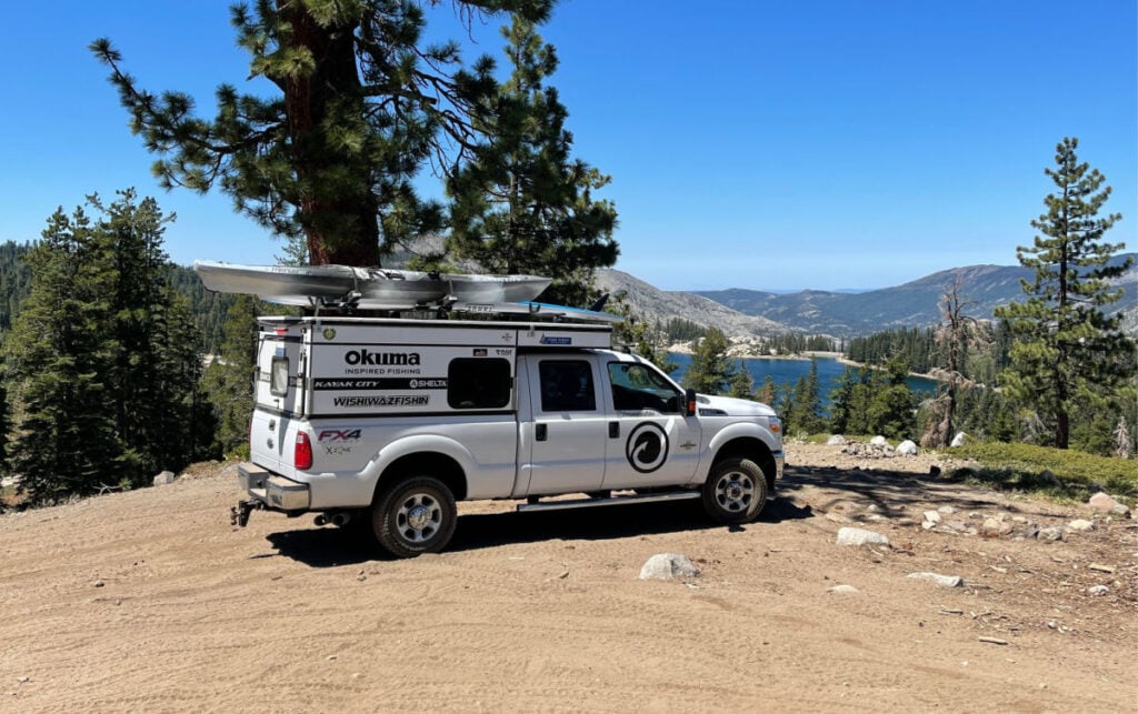 four wheel camper parked above an alpine lake
