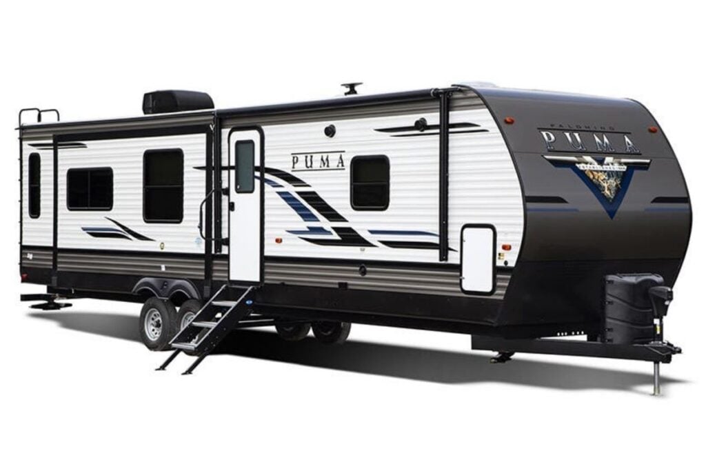 Palomino Puma travel trailer exterior wit white and grey siding and blue and black decals