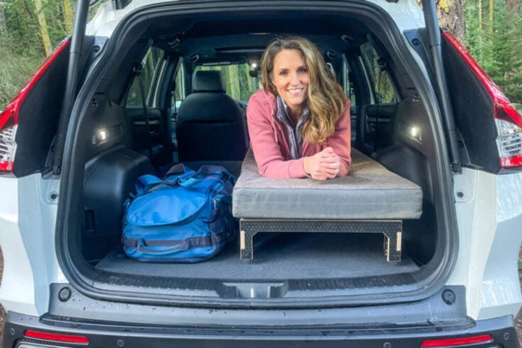 woman on camping bed. in hatchback car