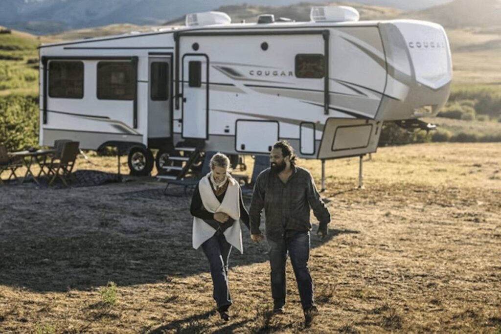 happy couple outside a travel trailer