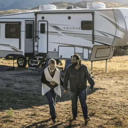 happy couple outside a travel trailer