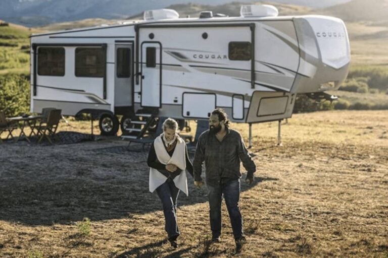 happy couple outside a travel trailer