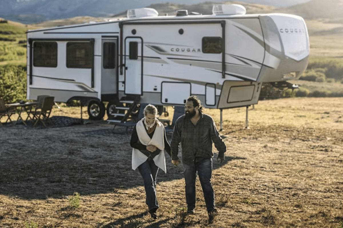 happy couple outside a travel trailer