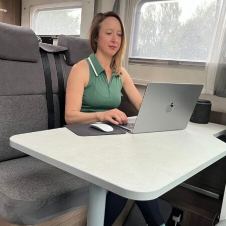woman typing on a computer in a campervan