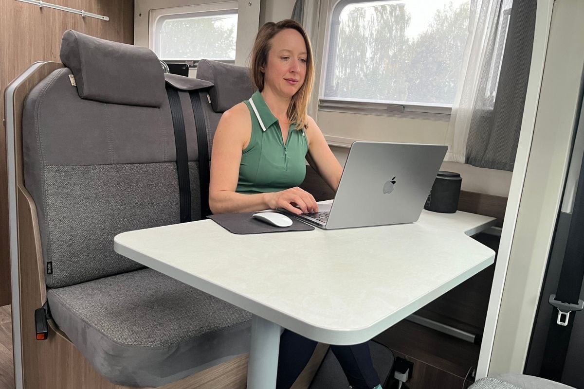 woman typing on a computer in a campervan
