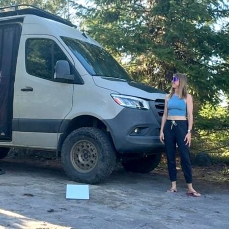 woman standing next to Sprinter van and Starlink Mini