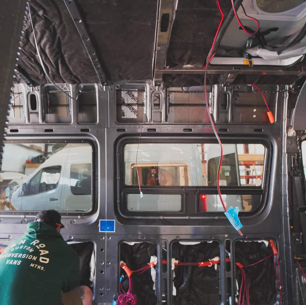 man installing thinsulate van insulation kit in a sprinter van
