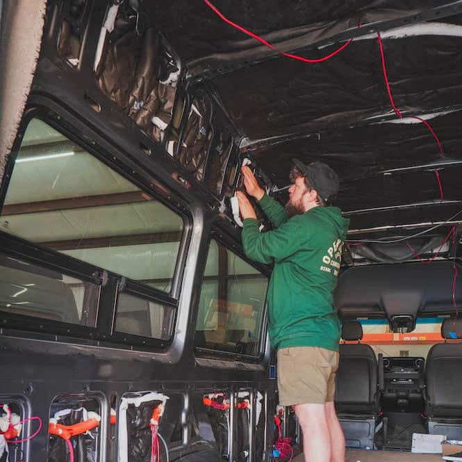 worker installing thinsulate van insulation in a sprinter van