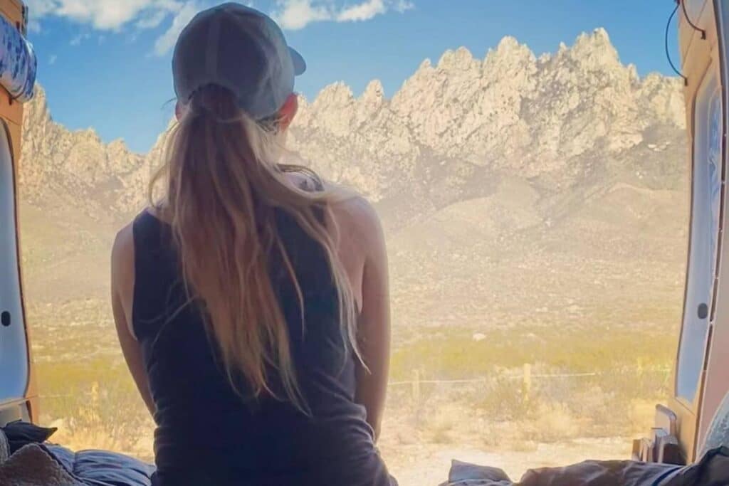 woman watching the mountain while sitting in a van