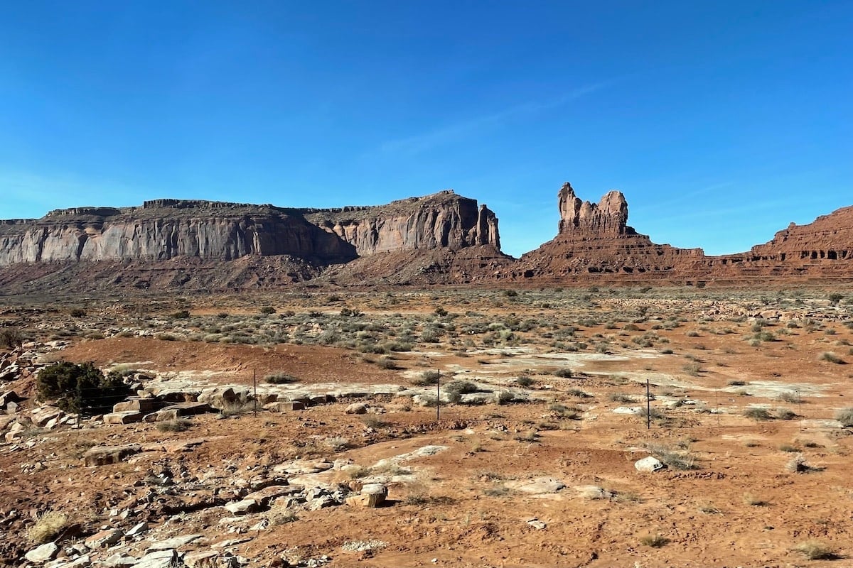 Red rock formations in Monument Valley in Utah with a blue sky in the background.