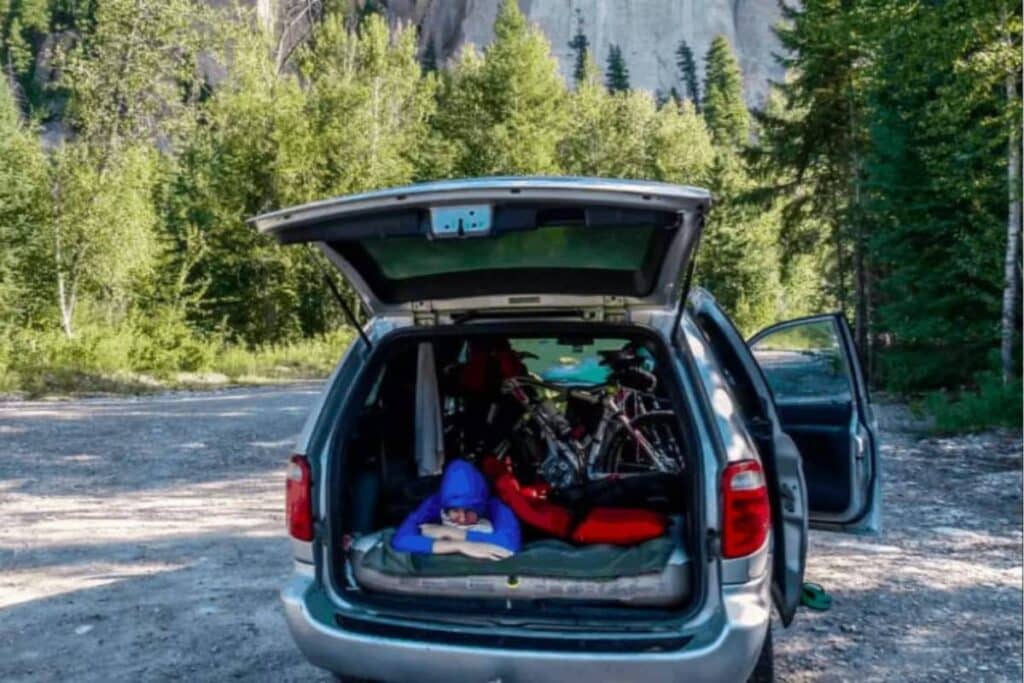 woman sleeping inside a minivan camper