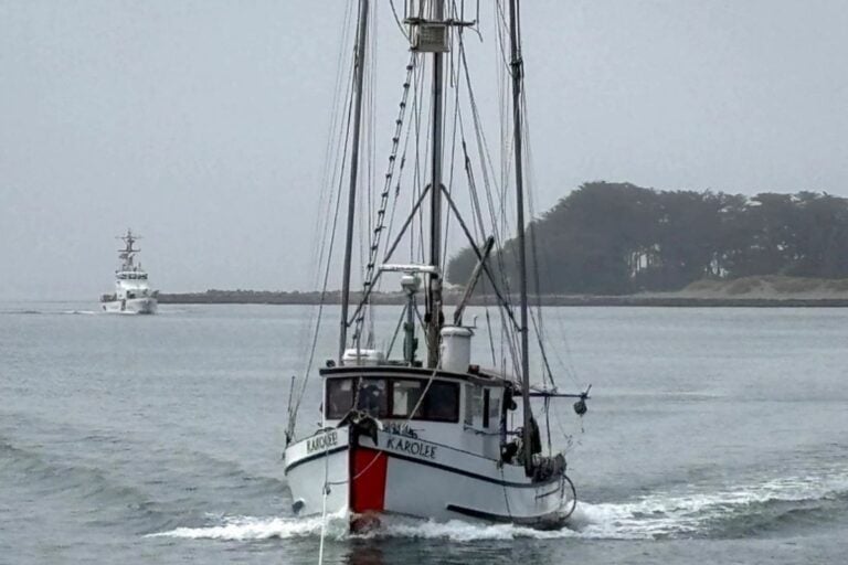 fishing boat getting towed into port