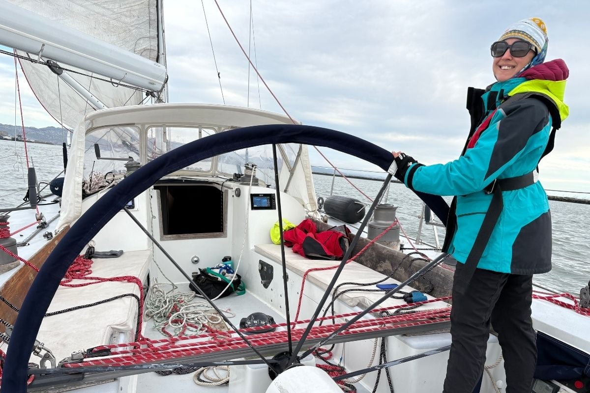 kristin behind the wheel of nelson marek sailboat