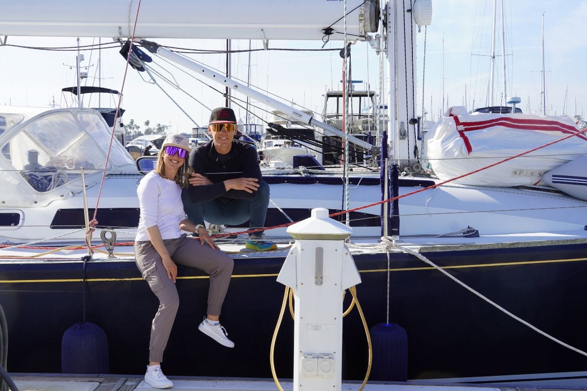 man and woman sitting on sailboat