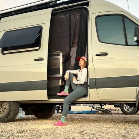woman sitting in the door of her sprinter