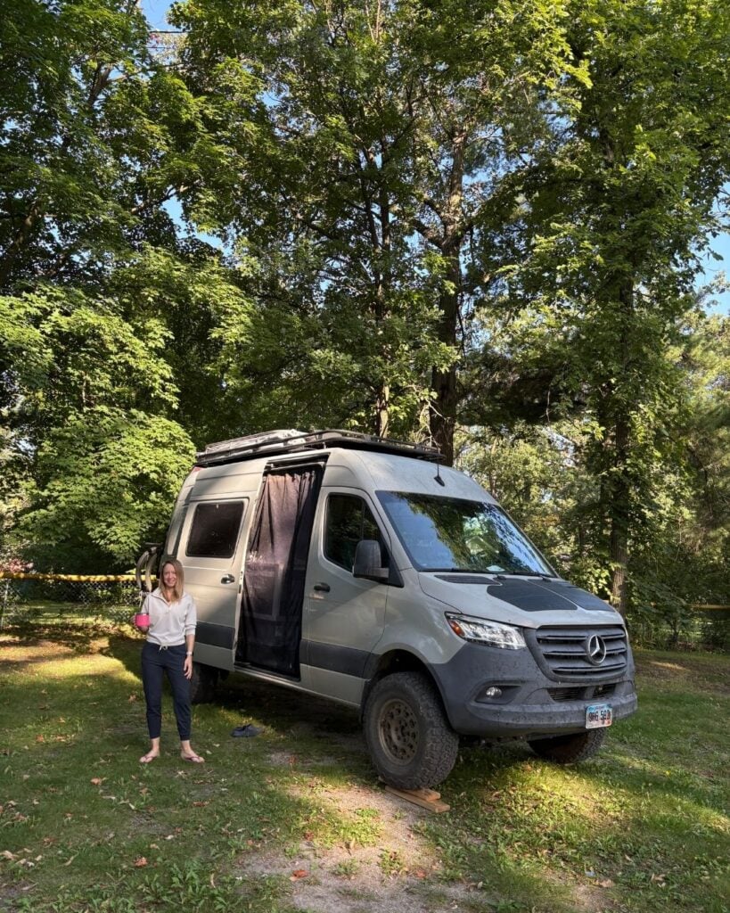 woman standing beside sprinter van