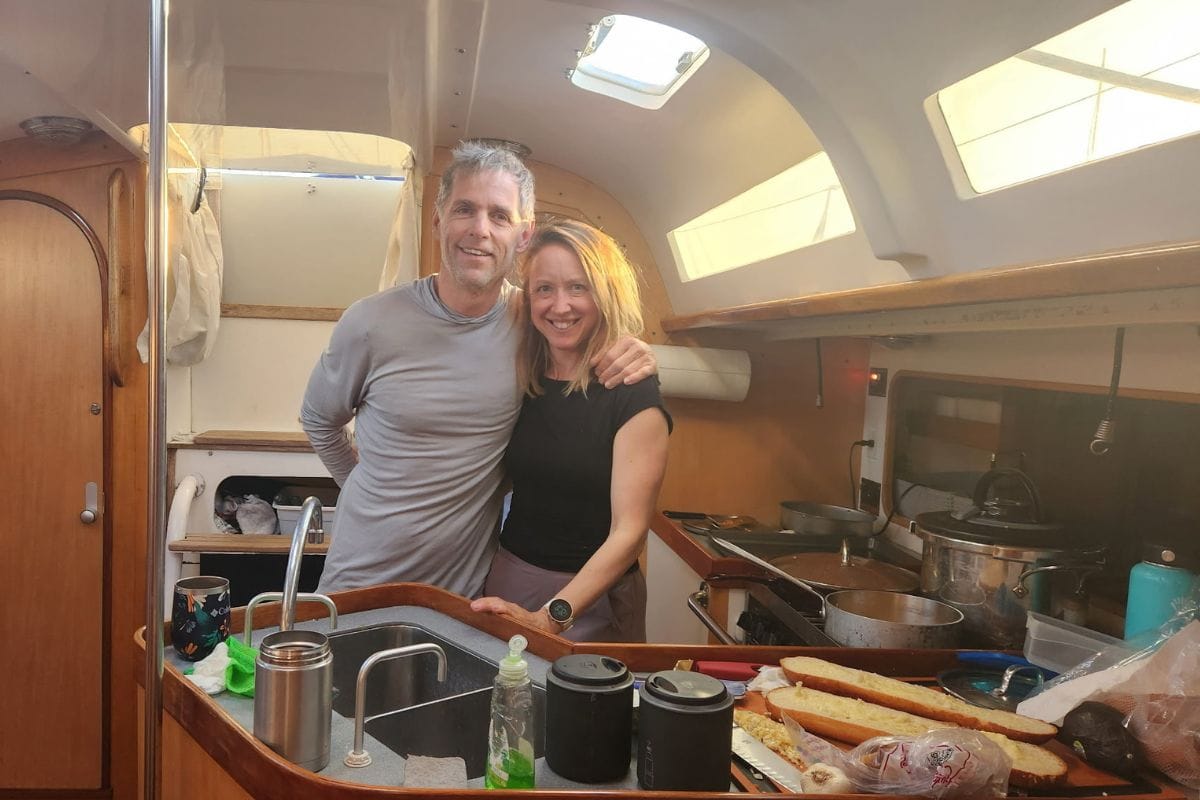 couple standing in sailboat galley