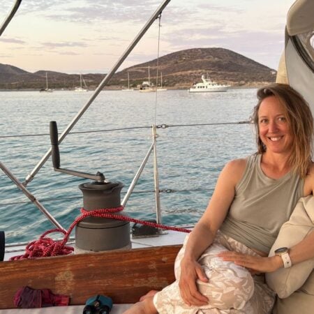 woman sitting in the cockpit of a sailboat