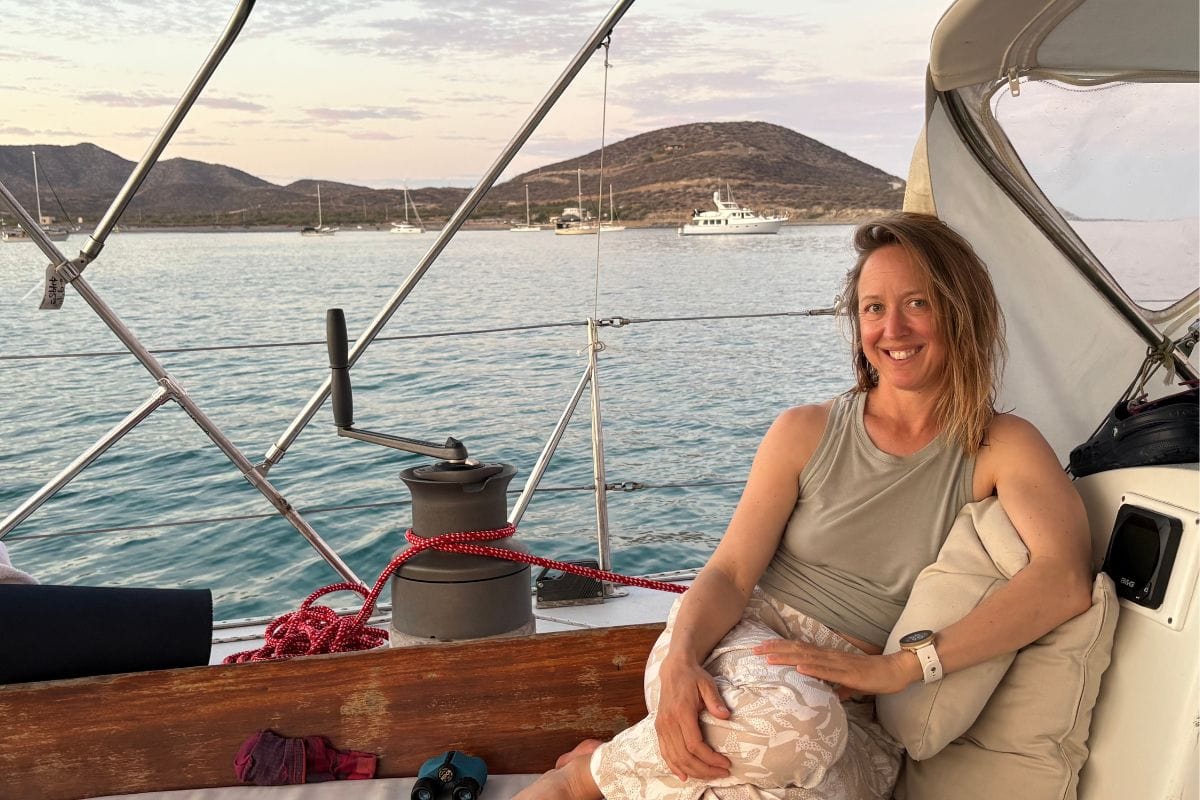 woman sitting in the cockpit of a sailboat
