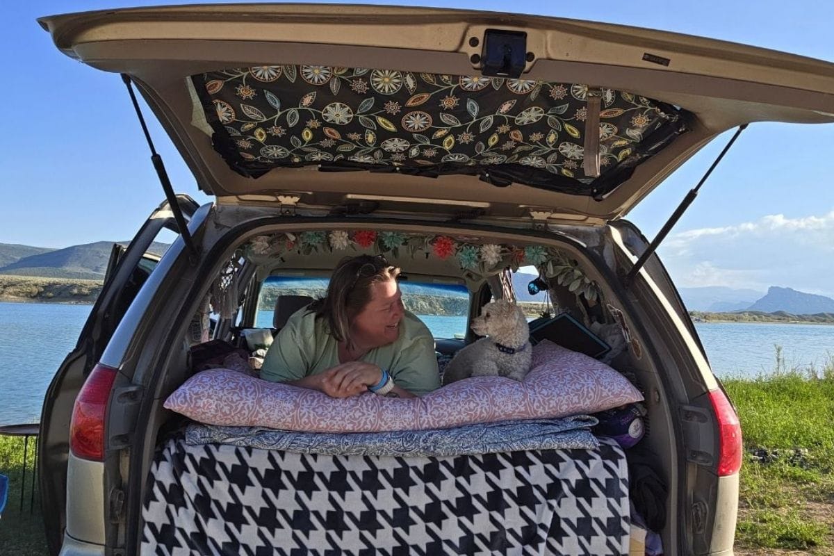 woman and her dog in the back of a minivan