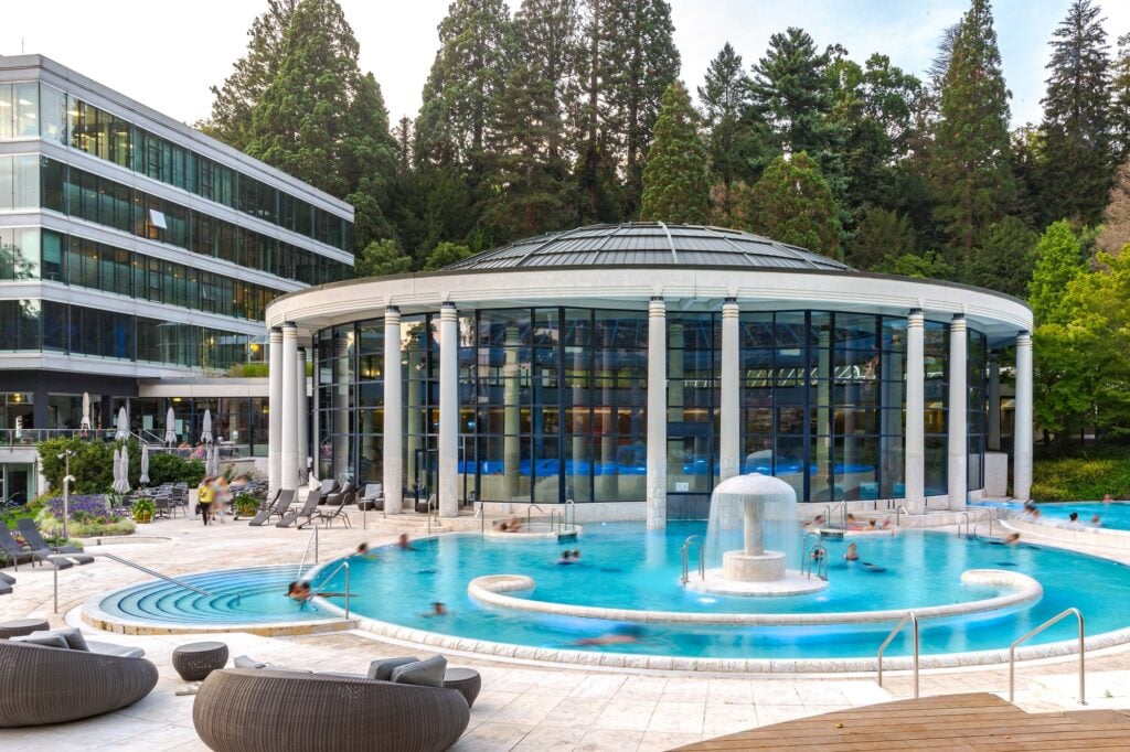 Outdoor thermal pool at Caracalla Spa in Baden-Baden with the domed indoor pool behind