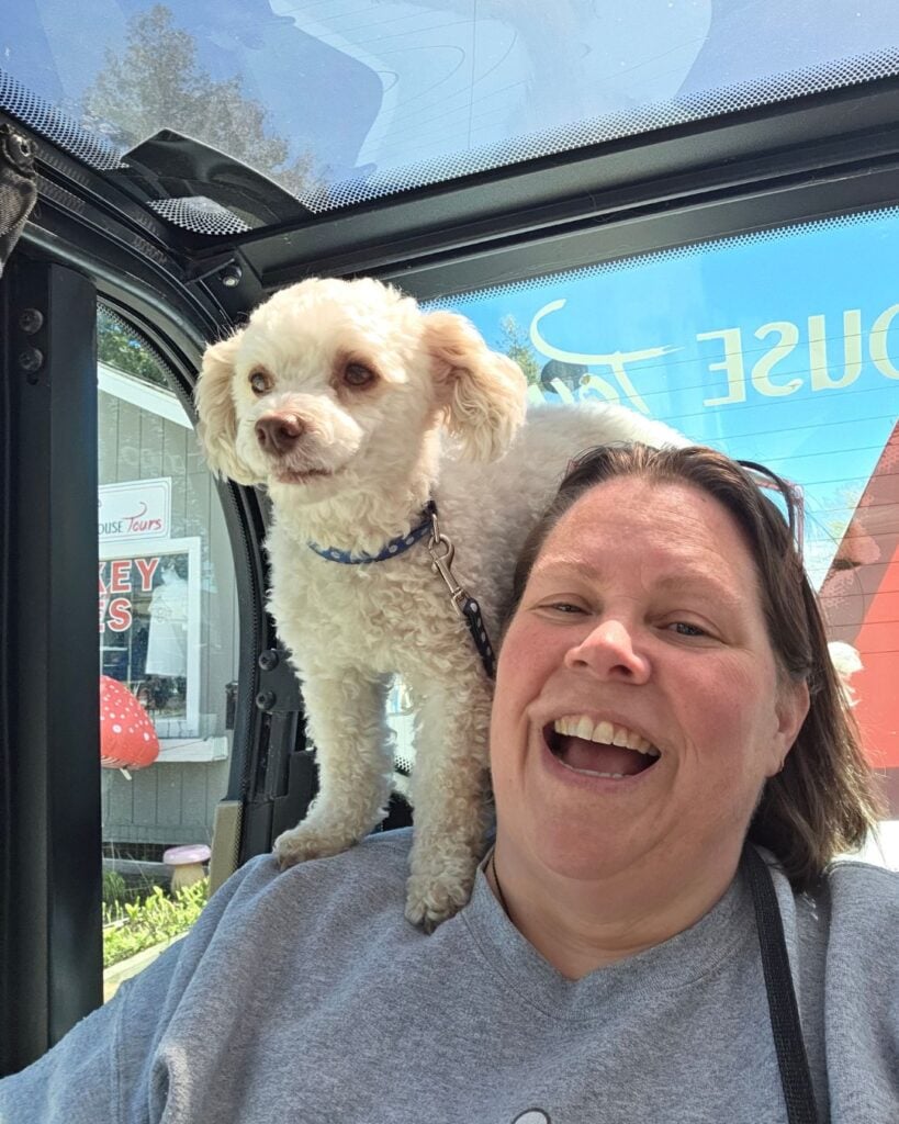 woman with white dog on her shoulder