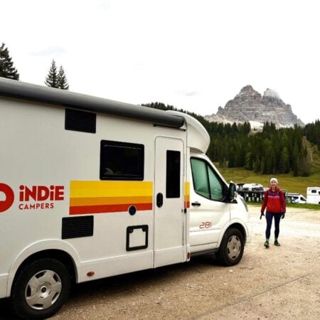 woman standing by an indie campervan rental in Europe