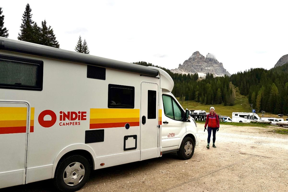 woman standing by an indie campervan rental in Europe