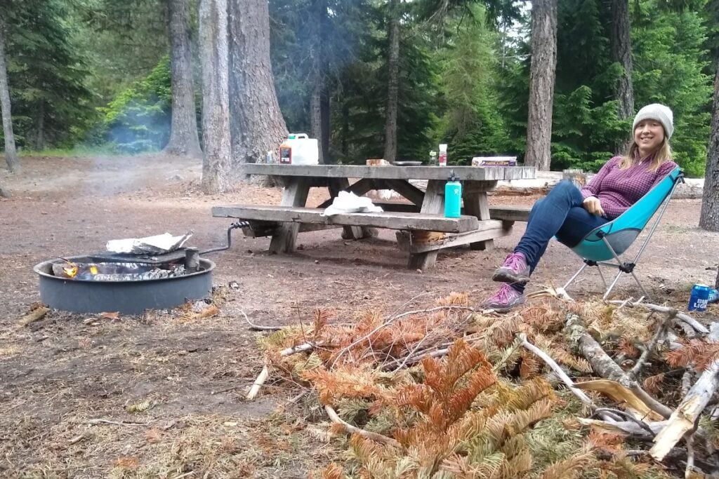 woman sitting in camp chair in the forest