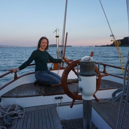 woman sitting on stern of a sailboat