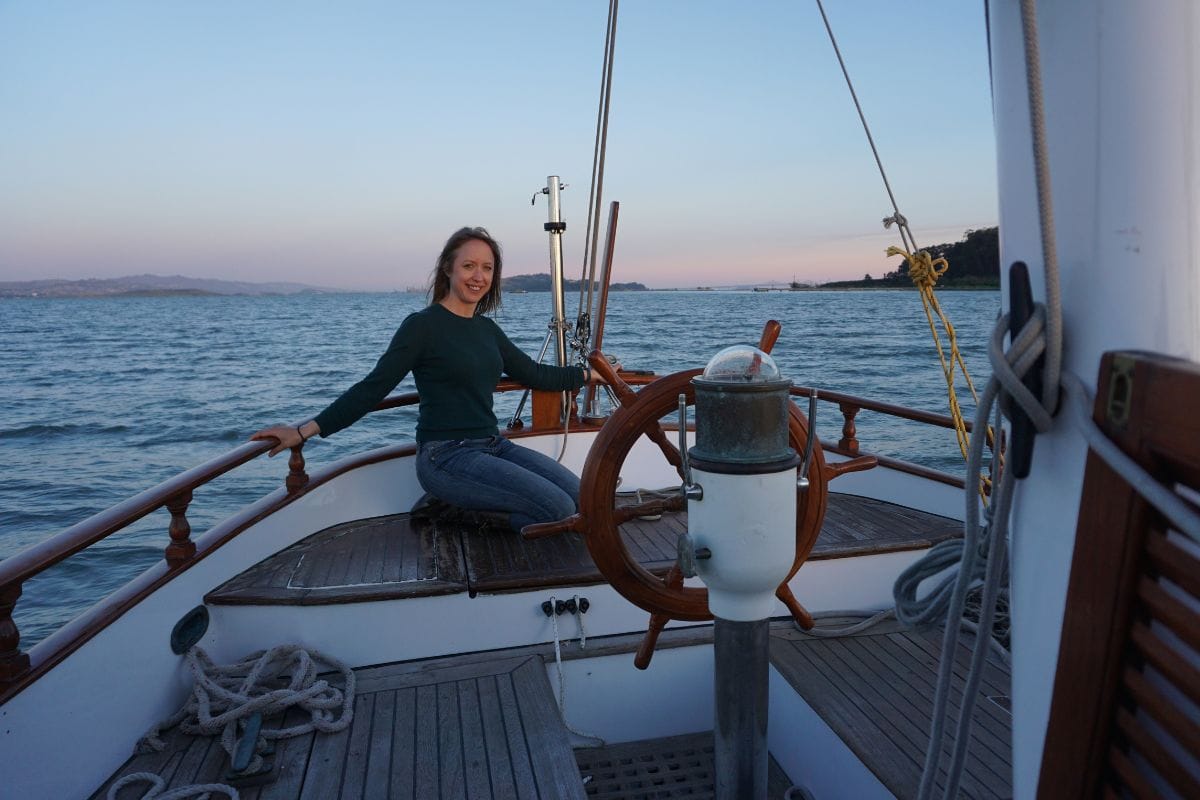 woman sitting on stern of a sailboat