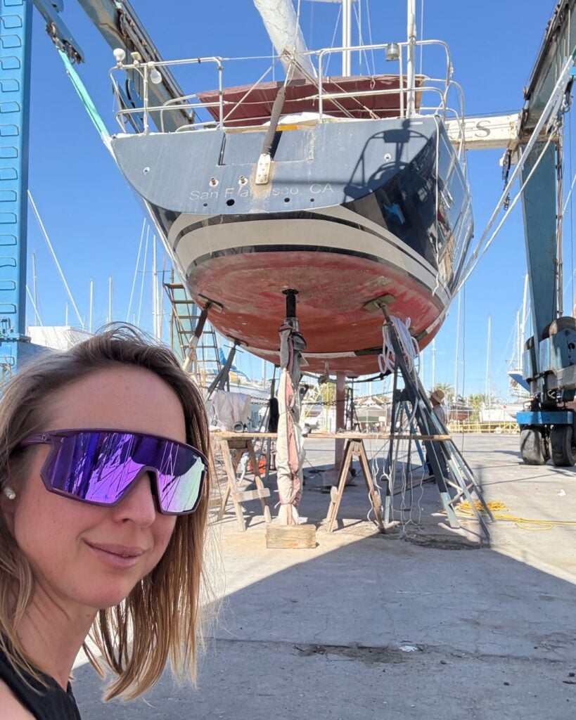 woman with sailboat in a boatyard