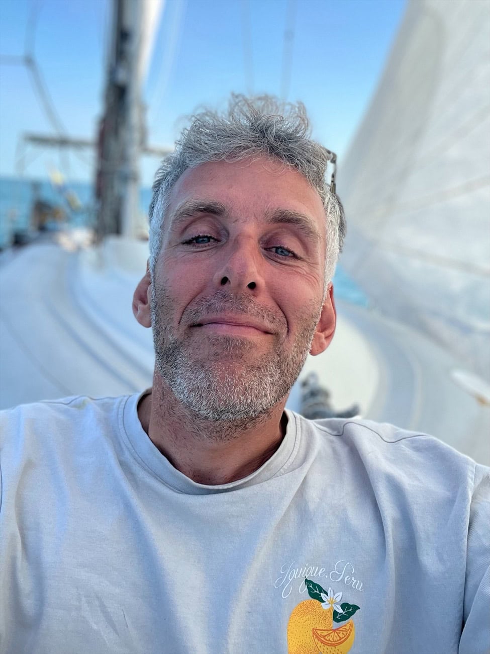 Fredrik smiling on the deck of his sailboat