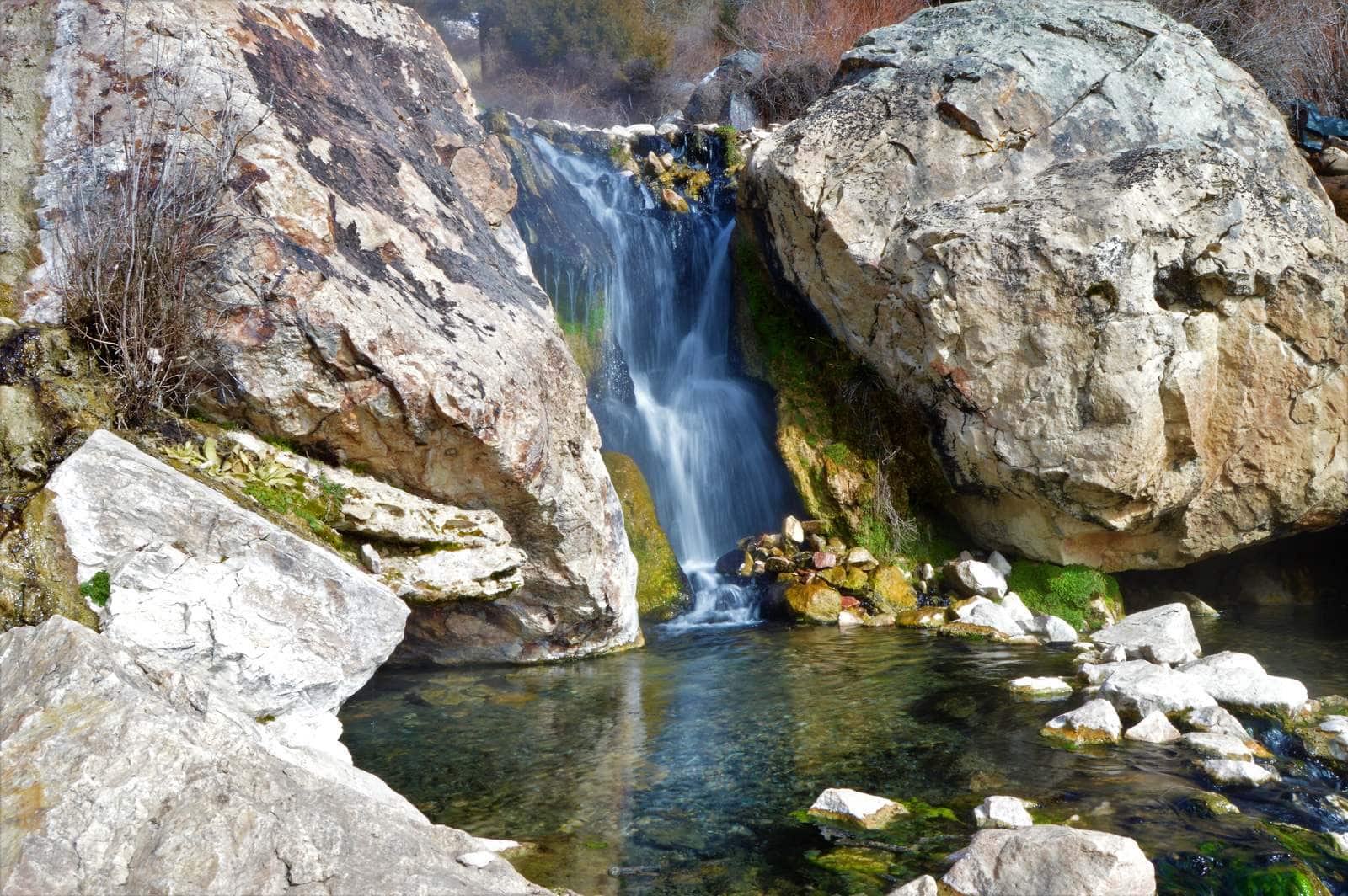 Steaming pools below the waterfall with mountain backdrop, Goldbug Hot Springs