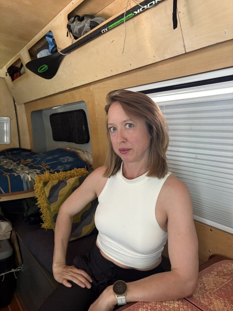 Kristin Hanes sitting on the bed inside her Sprinter van