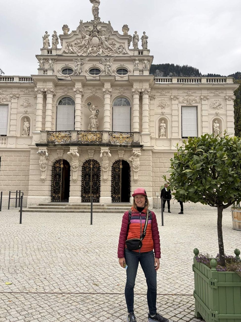 Kristin standing in front of the ornate facade of Linderhof Palace in Bavaria
