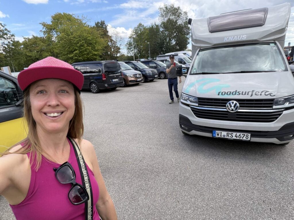 Kristin taking a selfie in front of a Roadsurfer Van Villa campervan at the Munich rental depot