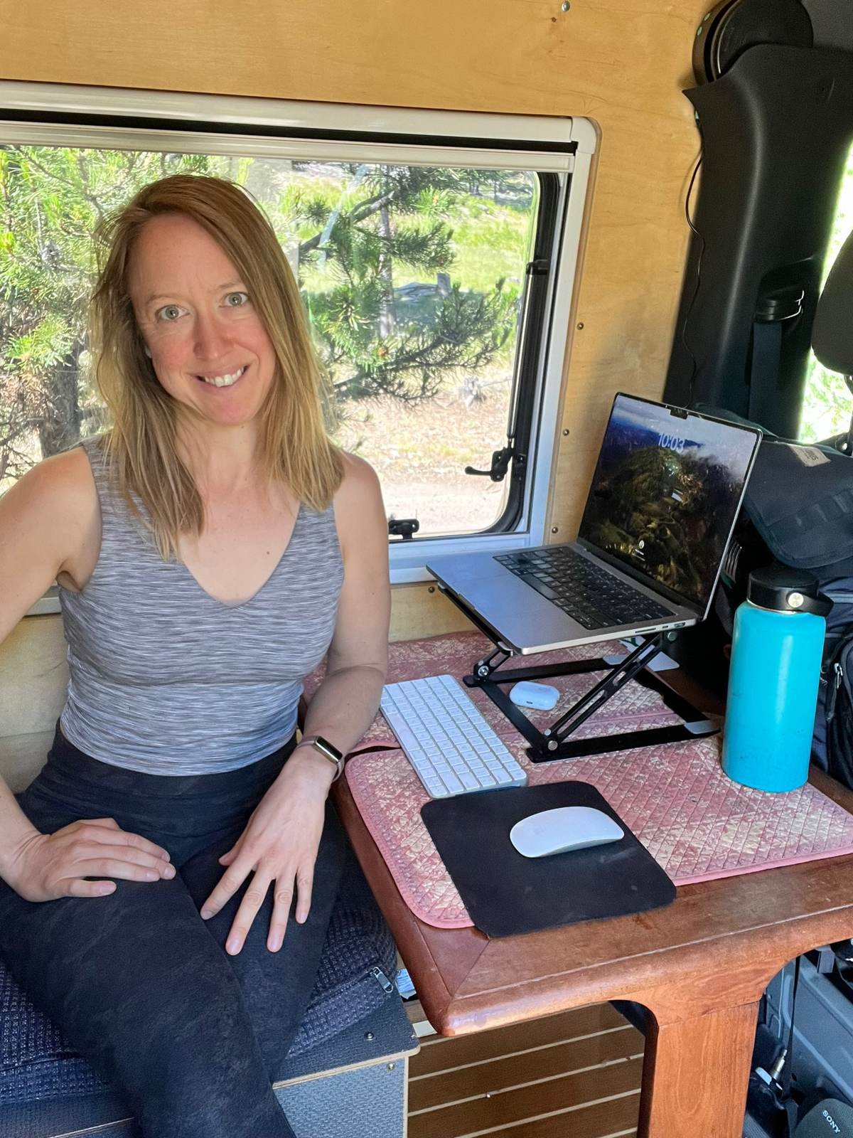 Kristin working at the small desk inside her campervan