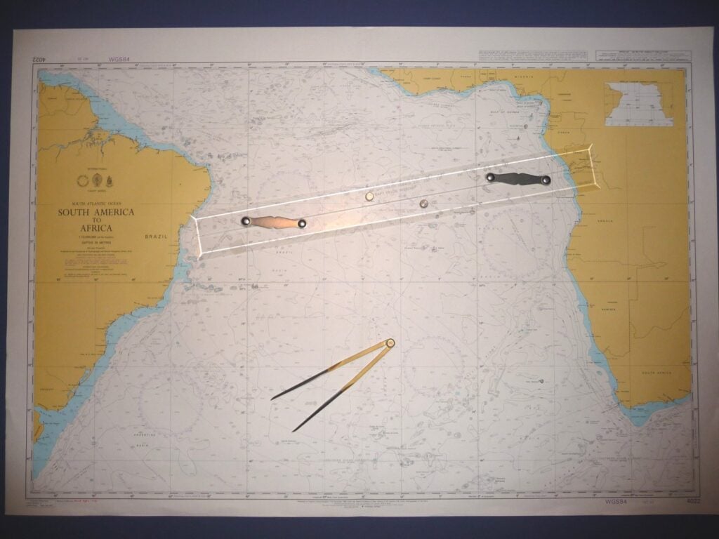 A paper nautical chart with parallel rules and dividers