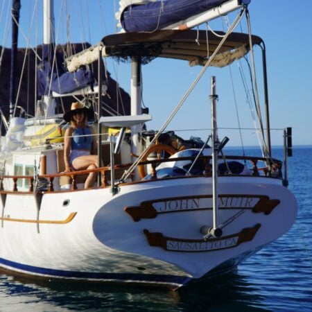Kristin Hanes's 1972 ketch at anchor in the Sea of Cortez, bow on, with her in the cockpit