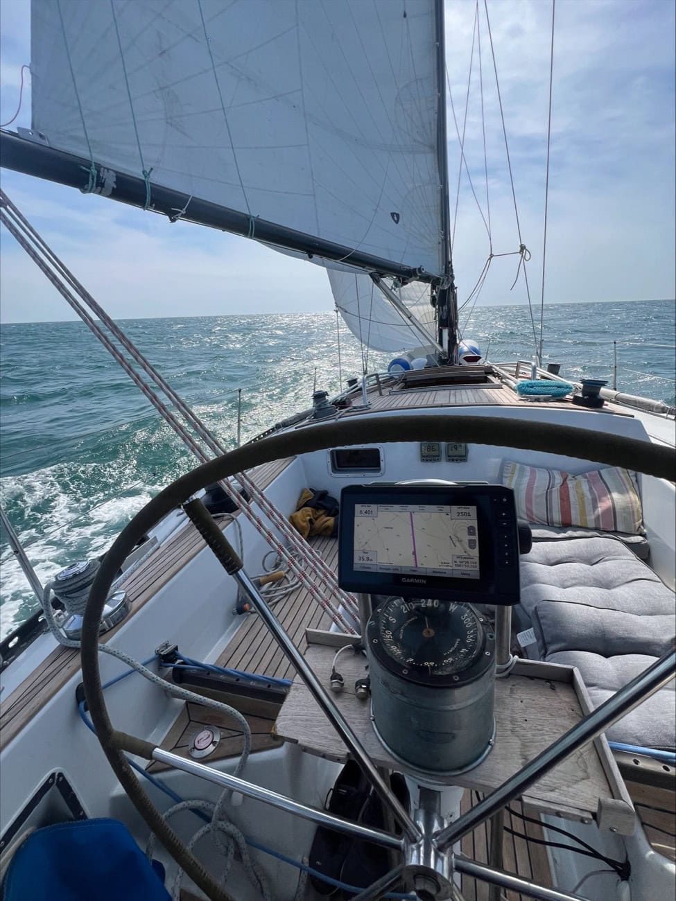 Looking forward over the bow of a sailboat under sail on open water