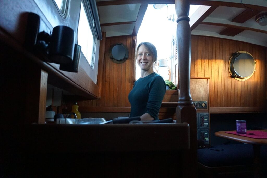 Kristin at the cabin table of her CT-41 ketch in the San Francisco Bay years, dark teak and warm light
