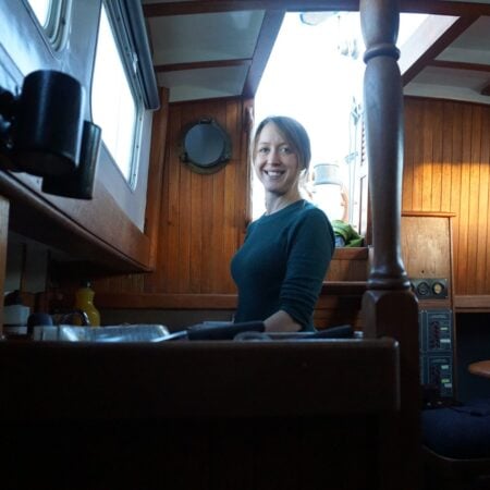 Kristin at the cabin table of her CT-41 ketch in the San Francisco Bay years, dark teak and warm light