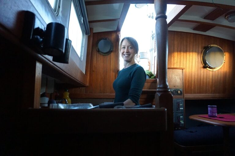Kristin at the cabin table of her CT-41 ketch in the San Francisco Bay years, dark teak and warm light